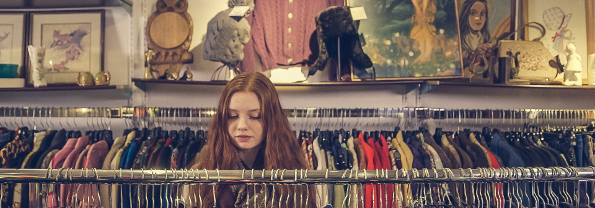 Racks of clothing and shelves of collectibles inside a thrift store