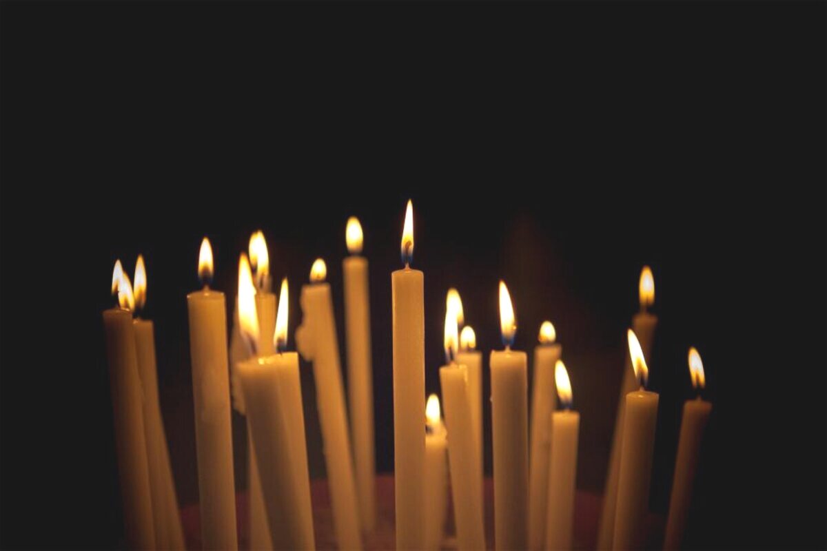 A row of lit memorial candles